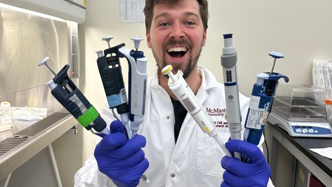 Person in lab cost with pipettes in hands