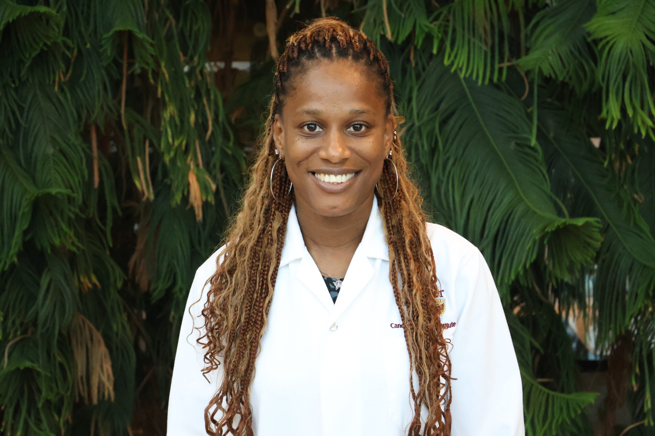 Person in a lab coat in front of a tree